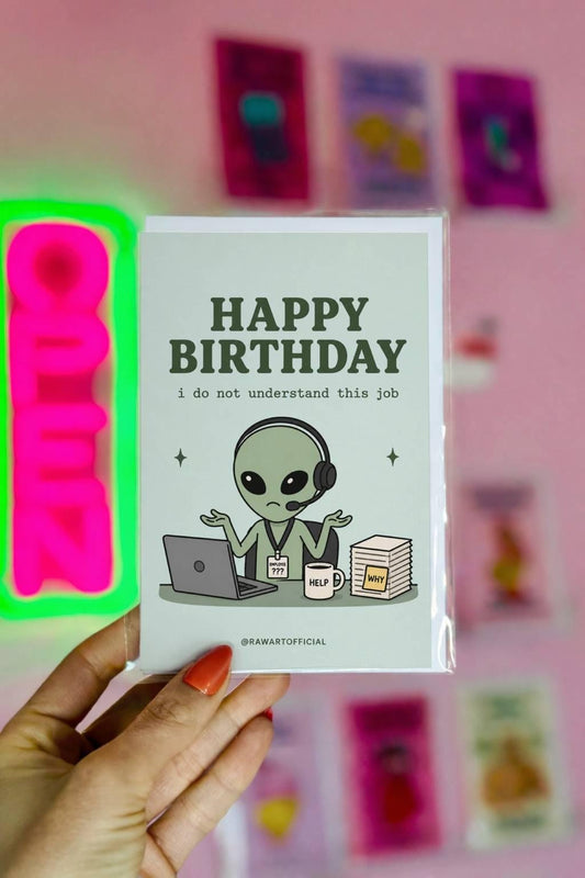 Funny coworker birthday greeting card with confused alien at desk with laptop and headset, text reads “Happy birthday I do not understand this job”