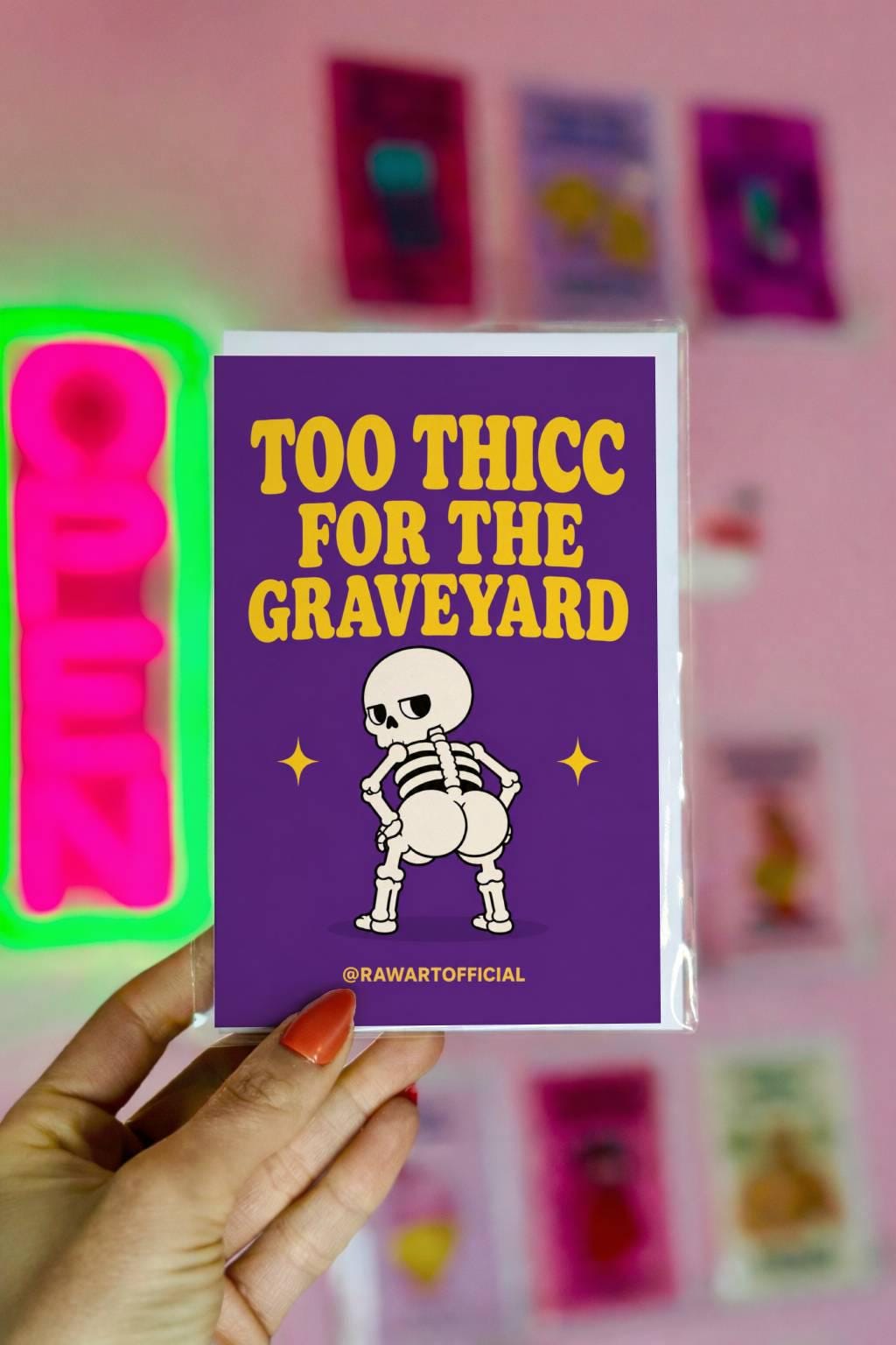 Funny Halloween greeting card with thick skeleton booty on purple background saying “Too Thicc For The Graveyard”