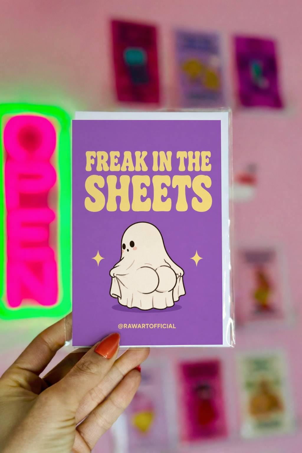 Funny Halloween greeting card with cute ghost booty character and retro text reading “Freak in the Sheets” on a lavender background.
