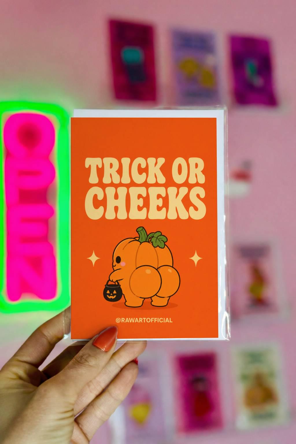 Funny Halloween greeting card with a cute pumpkin character from behind holding a candy bucket and the text “Trick or Cheeks” on an orange background.