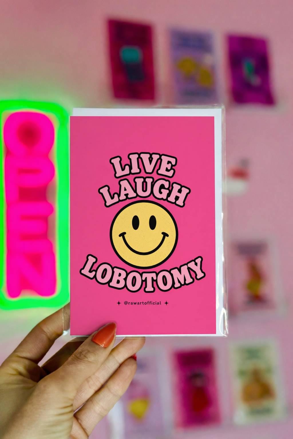 Funny pink greeting card with a retro smiley face and the text “Live Laugh Lobotomy” in bubble lettering.