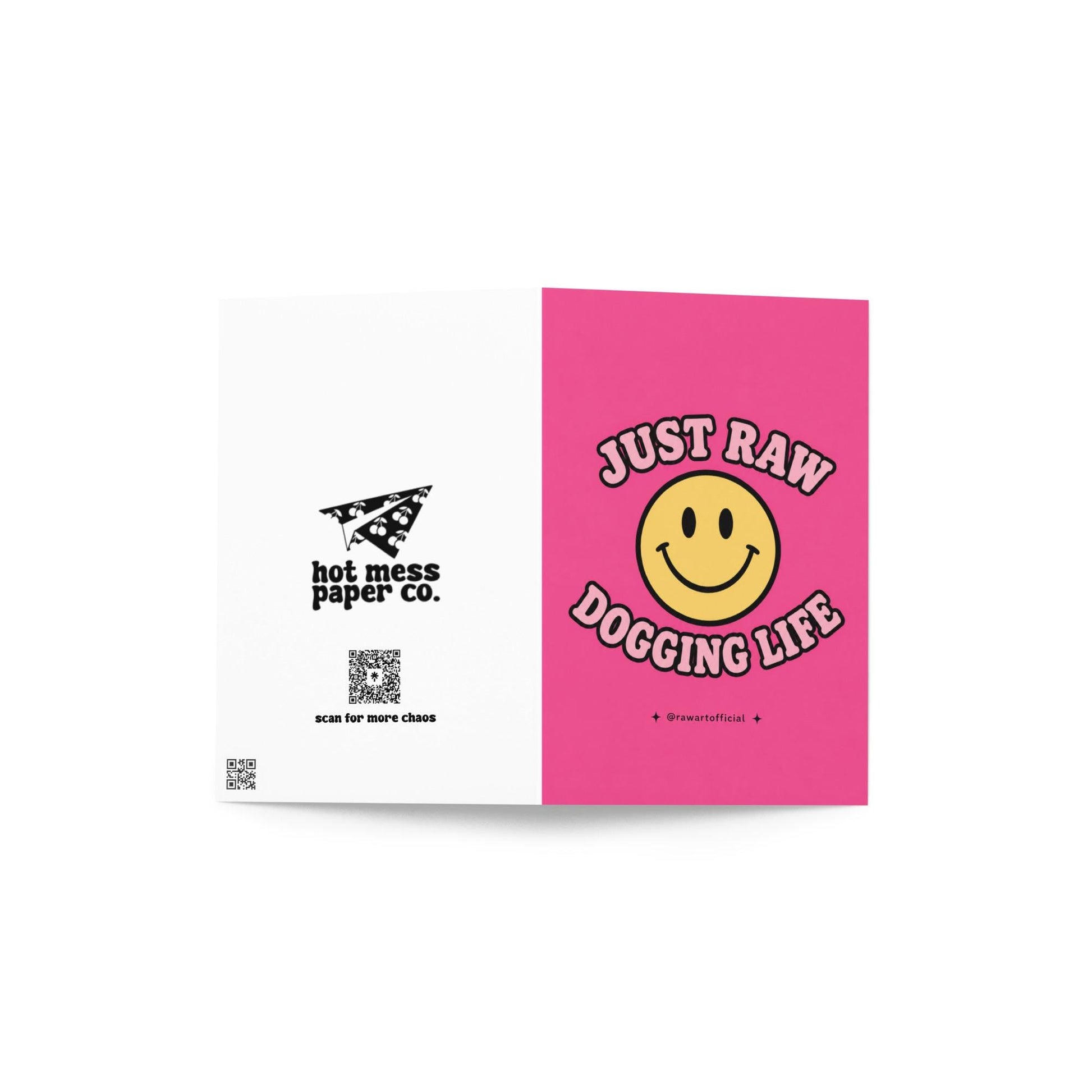 Funny pink greeting card with a retro smiley face and the text “Just Raw Dogging Life” in bubble lettering.