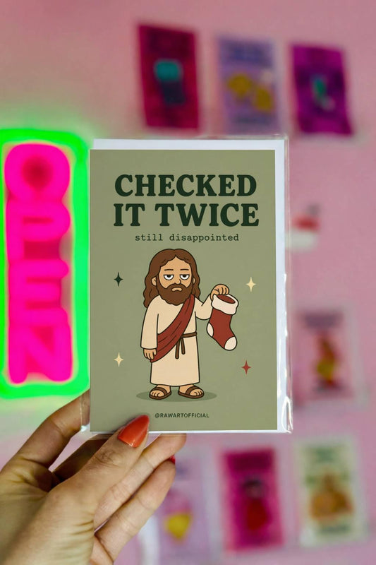 Funny Christmas greeting card with unimpressed Jesus holding a stocking on sage green background saying “Checked It Twice Still Disappointed”