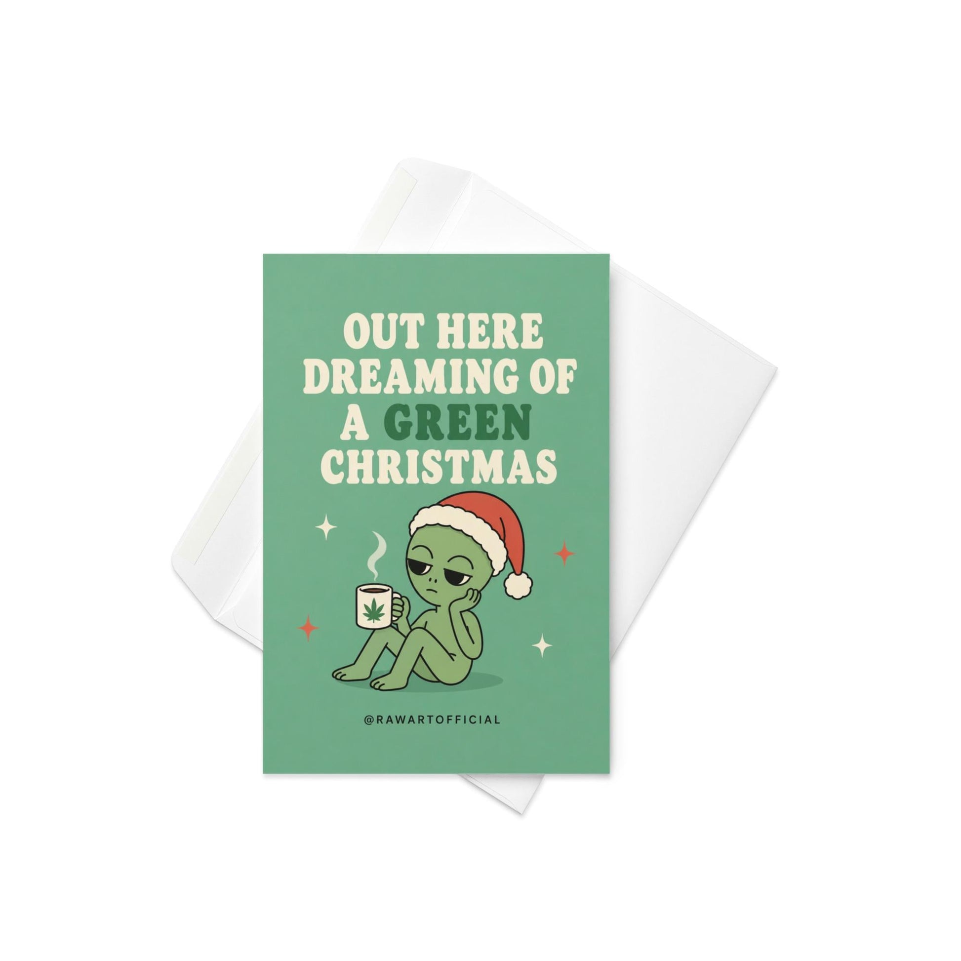 Funny Christmas card featuring an alien in a Santa hat holding a mug with a weed leaf beside the phrase “Out Here Dreaming Of A Green Christmas.”