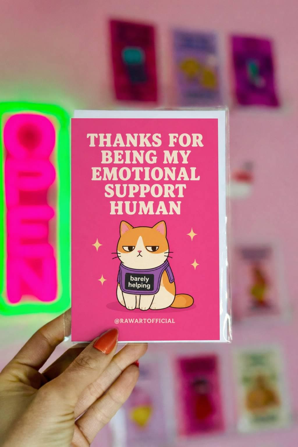 Funny appreciation card with a grumpy orange cat wearing a “barely helping” shirt beside the phrase “Thanks For Being My Emotional Support Human.”