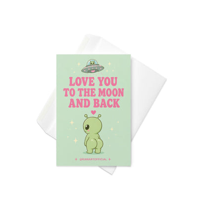 Funny love card featuring a cheeked-up alien under a UFO beside the phrase “Love You To The Moon And Back.”