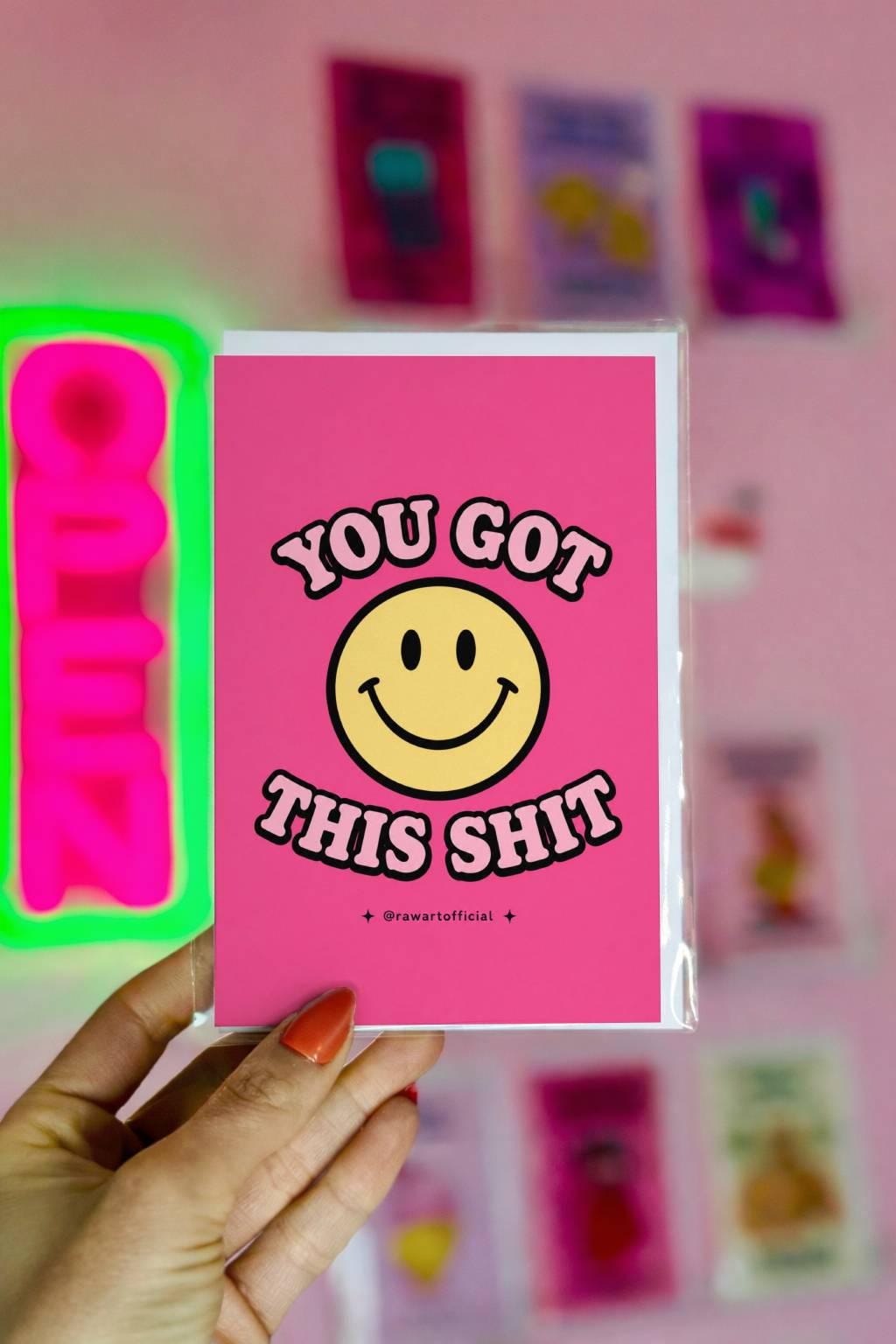Funny pink encouragement card with a retro smiley face and the phrase “You Got This Shit” in retro bubble lettering.