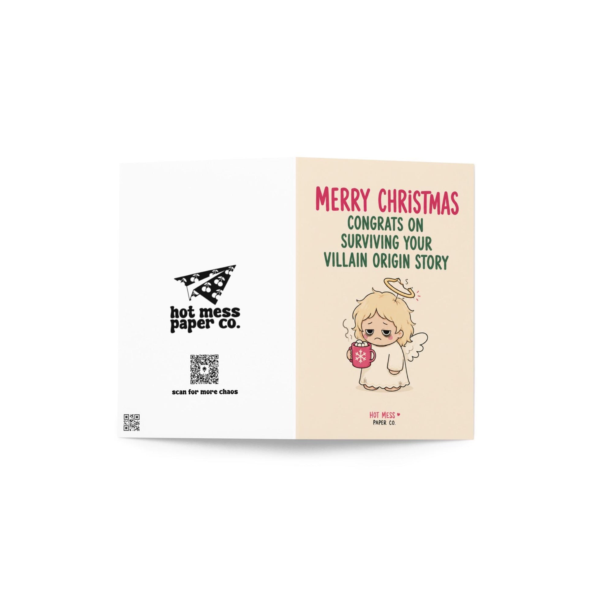 Funny Christmas card featuring a tired angel holding hot cocoa beside the phrase “Congrats On Surviving Your Villain Origin Story.”