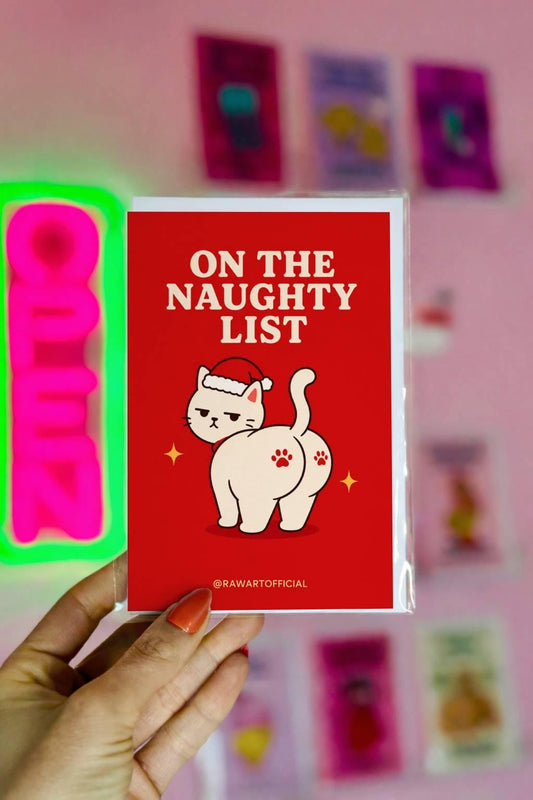 Funny Christmas card featuring a grumpy cat in a Santa hat beside the phrase “On The Naughty List.”