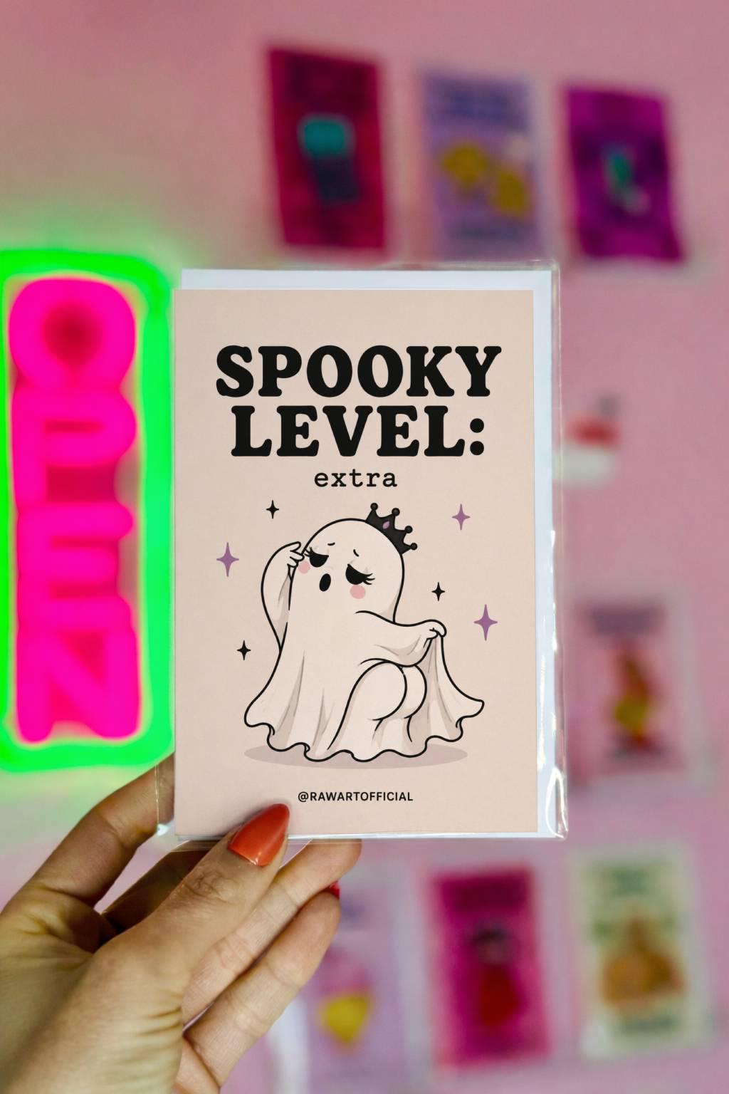 Funny Halloween card featuring a dramatic ghost wearing a crown beside the phrase “Spooky Level: extra.” Cute spooky ghost humor card.