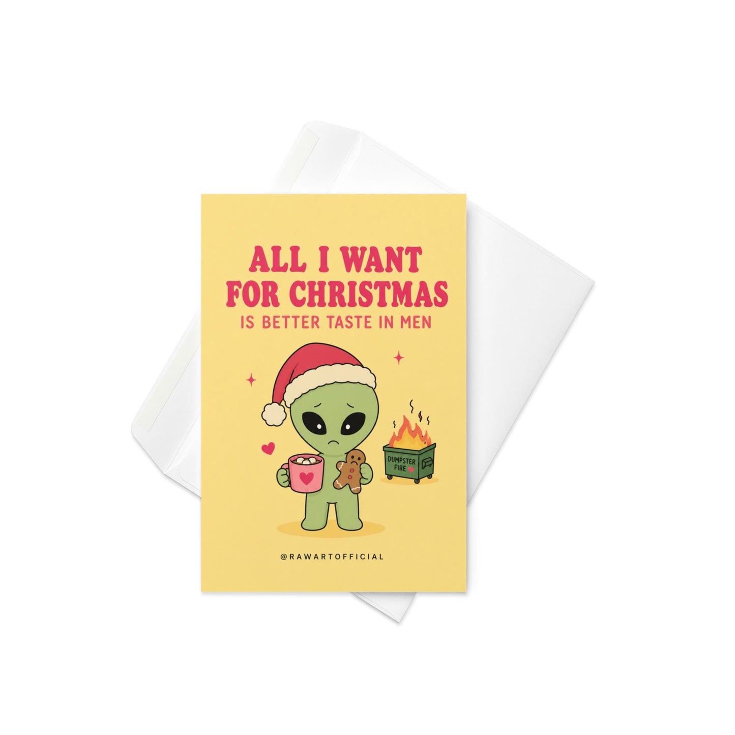 Funny Christmas card featuring a sad alien holding hot cocoa beside the phrase “All I Want For Christmas Is Better Taste In Men” with a tiny flaming dumpster.