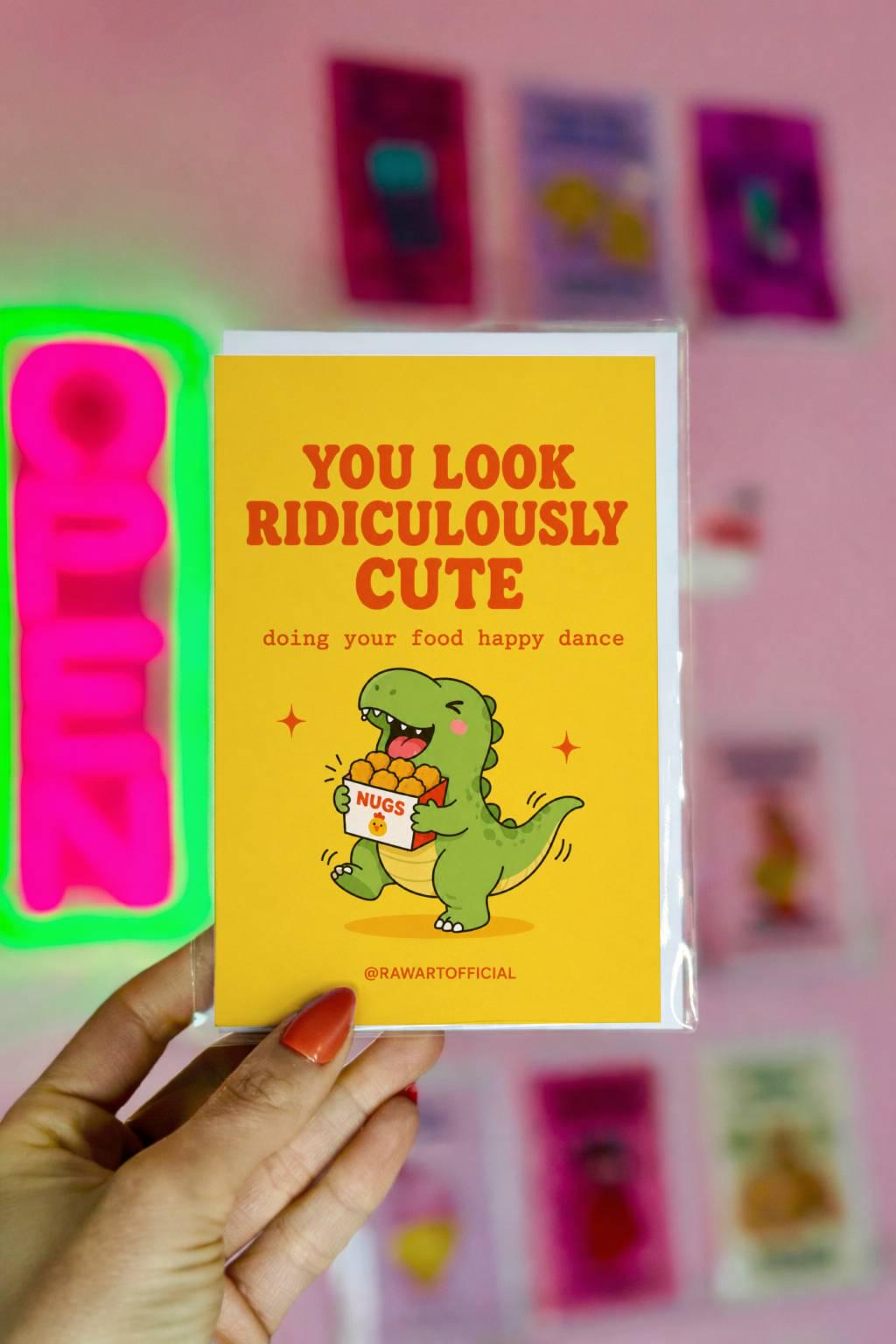 Funny greeting card featuring a happy dinosaur dancing with a box of chicken nuggets beside the phrase "You Look Ridiculously Cute Doing Your Food Happy Dance." Perfect for girlfriends, boyfriends, and food lovers.