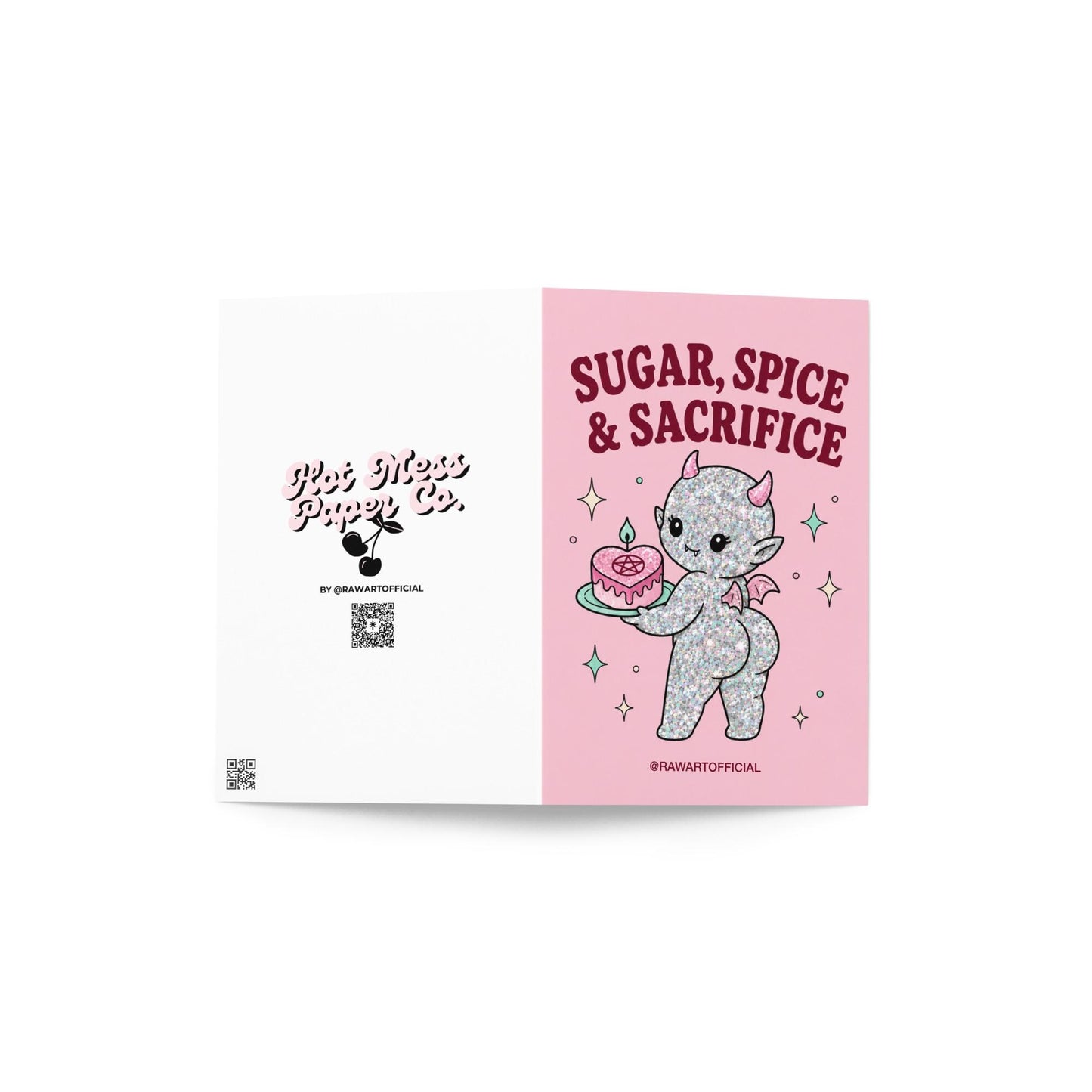 Pink funny Halloween greeting card reading “Sugar, Spice & Sacrifice” with a glittery cute devil holding a pink cake with a pentagram, photographed against a colorful pink card display.