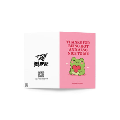 Funny love card featuring a green frog hugging a red heart beside the phrase “Thanks for Being Hot and Also Nice to Me.”