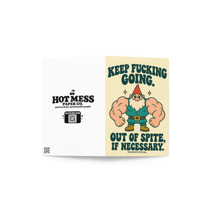 Funny encouragement greeting card featuring a muscular cartoon garden gnome with enormous flexing arms, an orange pointed hat, white beard, teal outfit, and brown boots. Cream background with bold dark green retro lettering reading “Keep Fucking Going. Out of Spite, If Necessary.” Sarcastic motivational card by Hot Mess Paper Co.