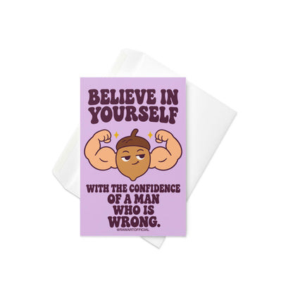 Funny encouragement greeting card with a pastel lavender background and bold dark purple retro lettering reading “Believe in Yourself With the Confidence of a Man Who Is Wrong.” Features a smug cartoon acorn flexing oversized muscular arms with golden sparkles. Sarcastic motivational humor by Hot Mess Paper Co.