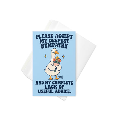 Funny sympathy greeting card featuring a cute white cartoon goose with an orange beak and feet holding a bouquet of pink and orange flowers, surrounded by golden sparkles on a pastel blue background. Bold navy retro lettering reads “Please Accept My Deepest Sympathy and My Complete Lack of Useful Advice.” Unconventional condolence card by Hot Mess Paper Co.