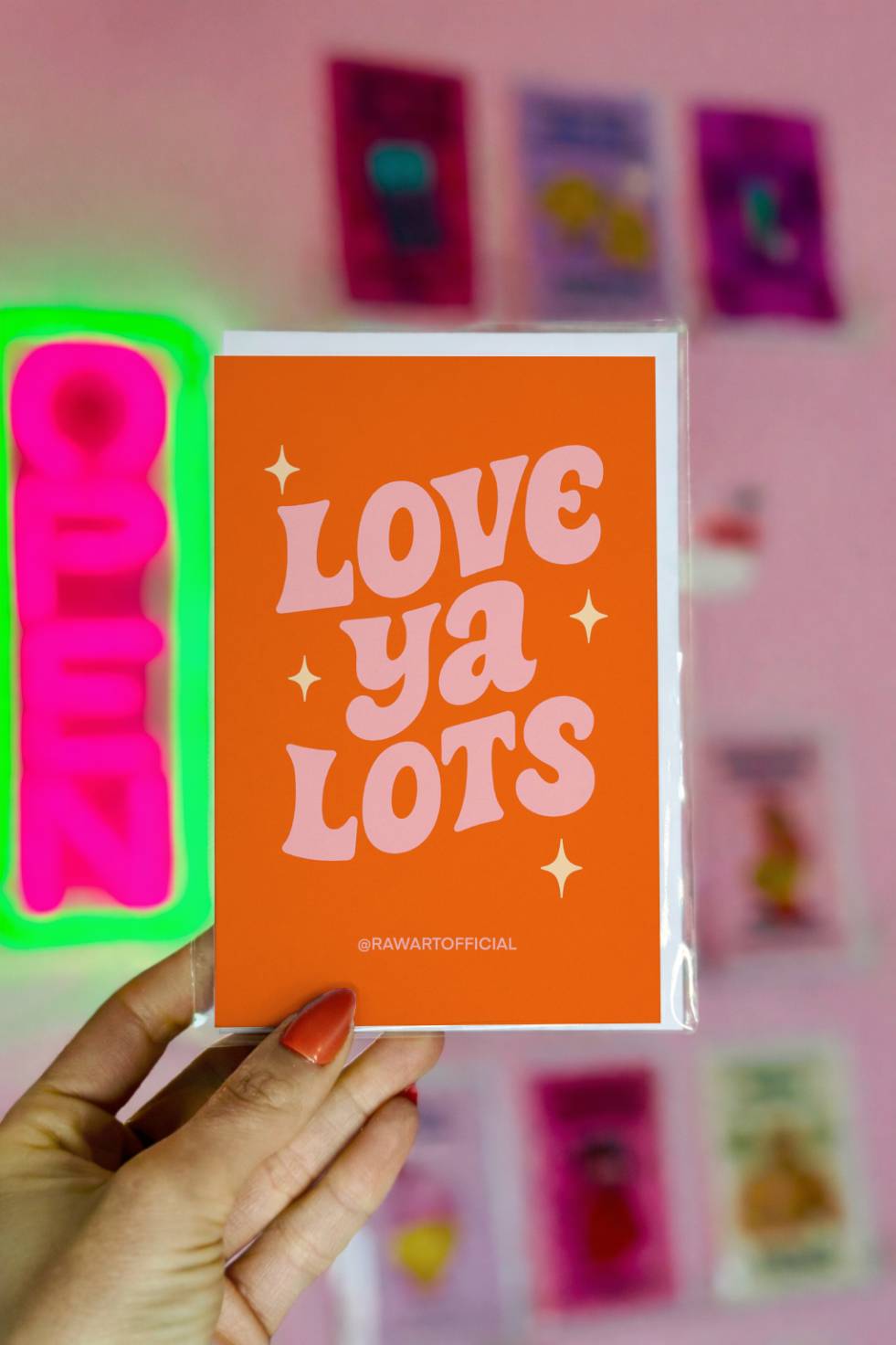 Greeting card with retro lettering reading “Love Ya Lots” on an orange background.