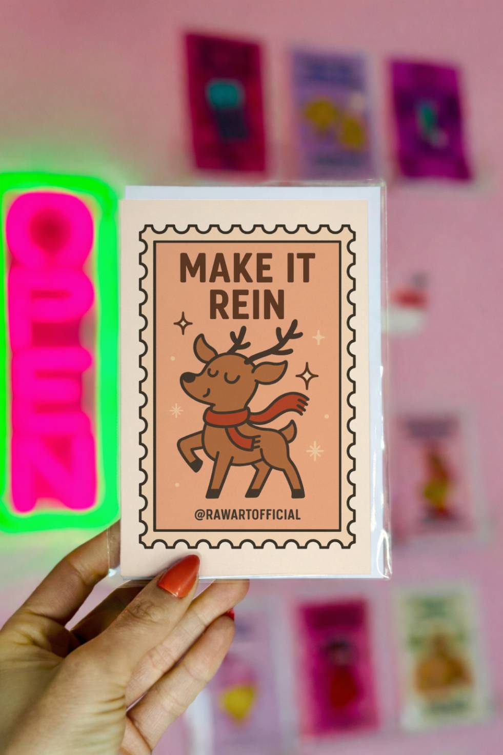 Funny Christmas card with cartoon reindeer wearing scarf and text “Make It Rein” in a tarot-style frame.