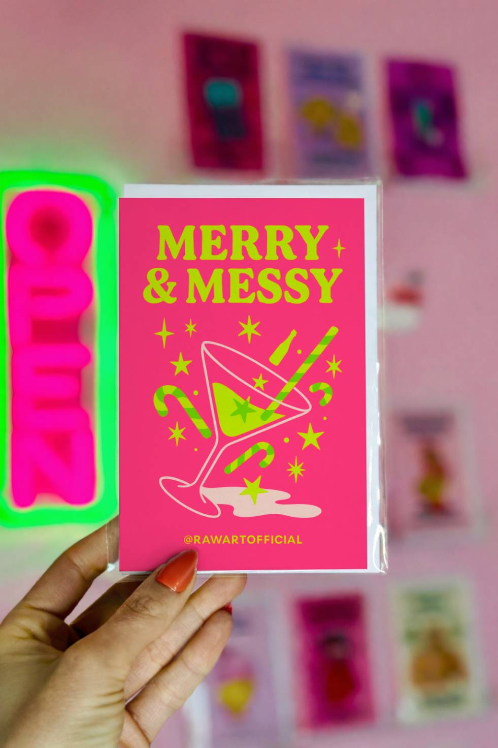 Funny Christmas greeting card featuring a spilled cocktail with candy canes and the phrase “Merry and Messy” on a bright pink background.