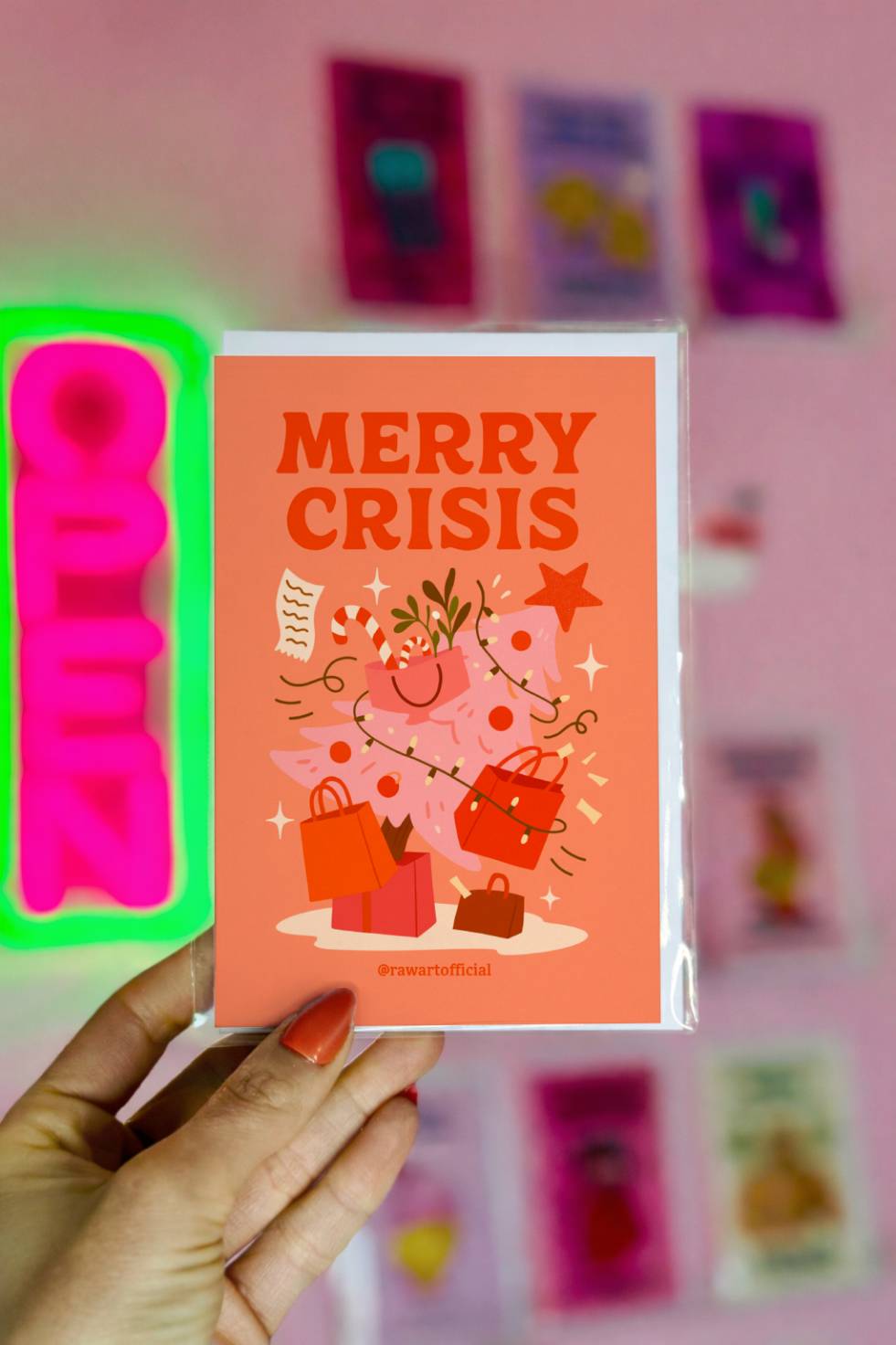 Funny Christmas greeting card with a chaotic Christmas tree full of shopping bags and decorations with the phrase “Merry Crisis.”
