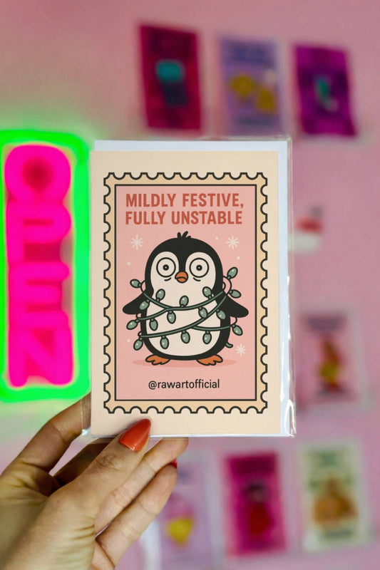 Funny Christmas card with penguin tangled in Christmas lights and text “Mildly Festive Fully Unstable.”