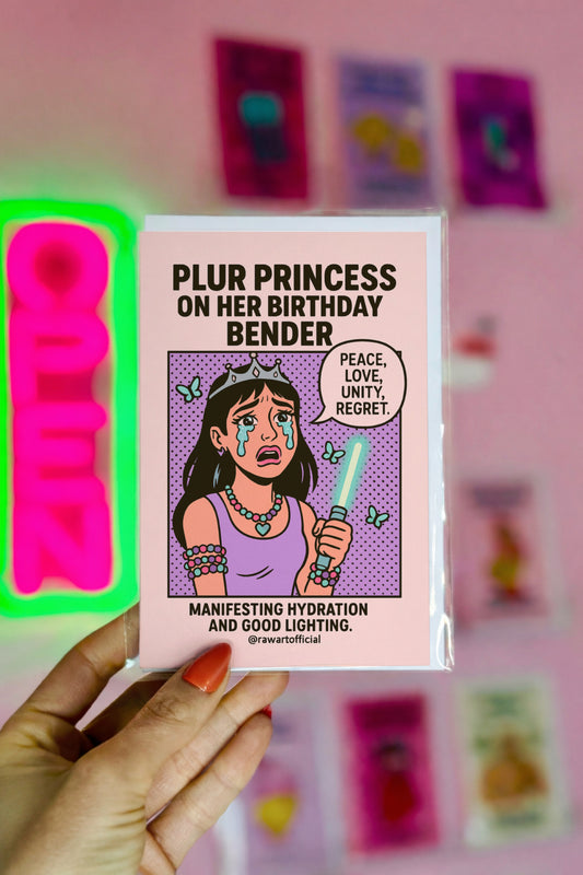 Cartoon card with text 'Plur Princess on her Birthday Bender' held by a hand against a pink background with colorful cards.