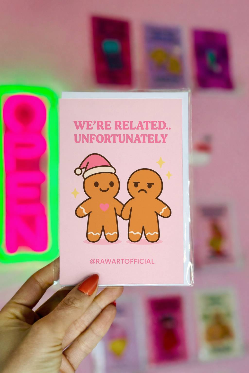 Funny Christmas card featuring two gingerbread characters holding hands with text “We’re related unfortunately” in a soft retro style design