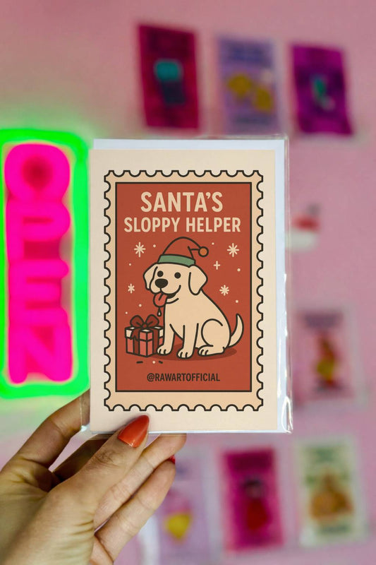 Retro Christmas greeting card featuring a Labrador dog wearing a Santa hat with a gift and text “Santa’s Sloppy Helper” in a vintage stamp-style design