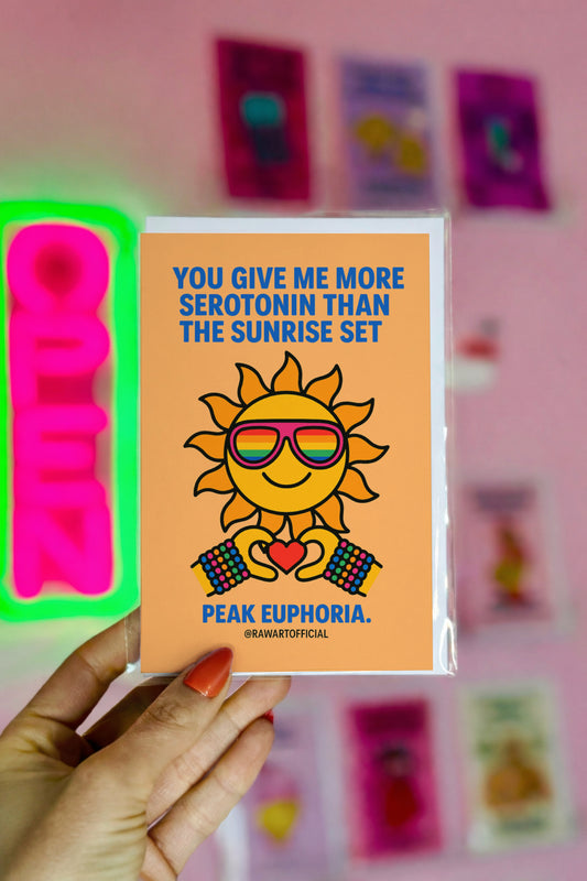 funny love card with smiling sun wearing rainbow sunglasses holding heart and text you give me more serotonin than the sunrise set