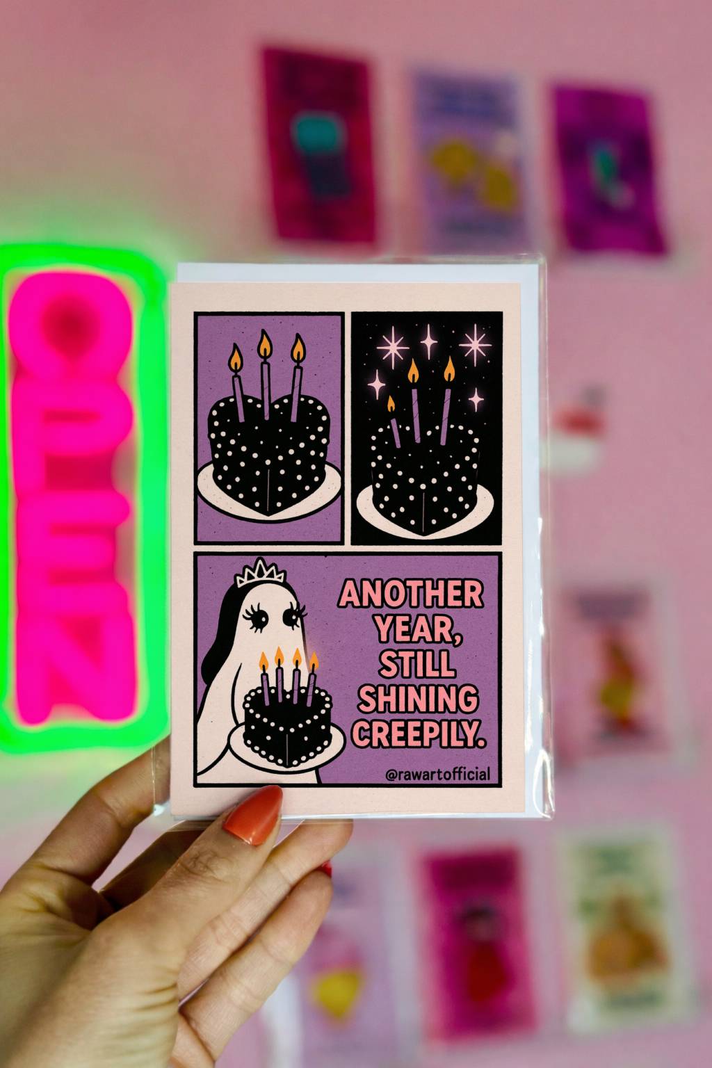 Spooky birthday greeting card featuring a ghost princess holding a black birthday cake with lit candles and the text “Another Year, Still Shining Creepily.”