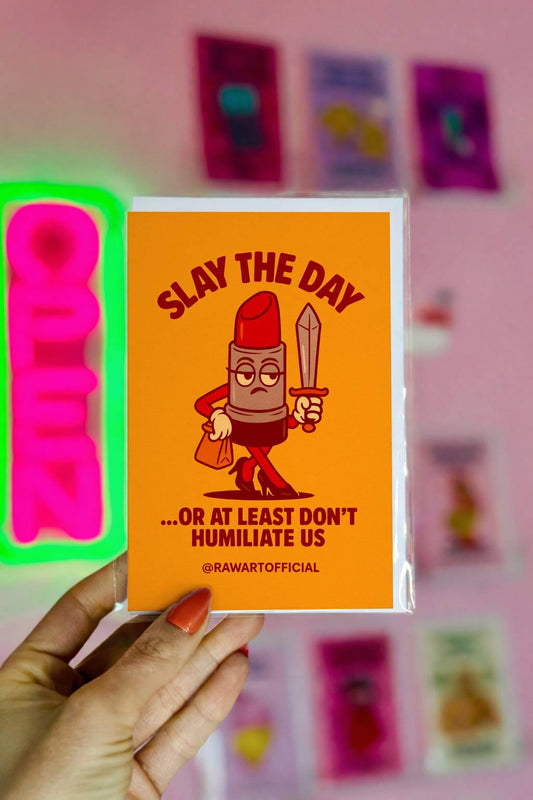 Greeting card featuring a cartoon lipstick character holding a sword with the text “Slay the Day… Or At Least Don’t Humiliate Us.”