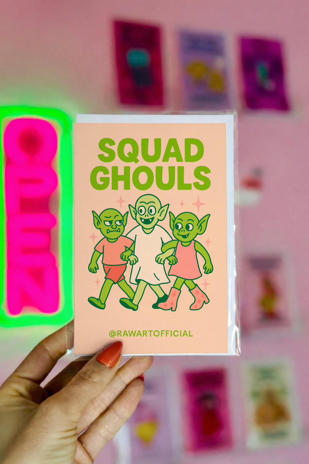 Greeting card featuring three cute green ghouls walking arm-in-arm on a peach background with the text “Squad Ghouls” in bold green lettering.