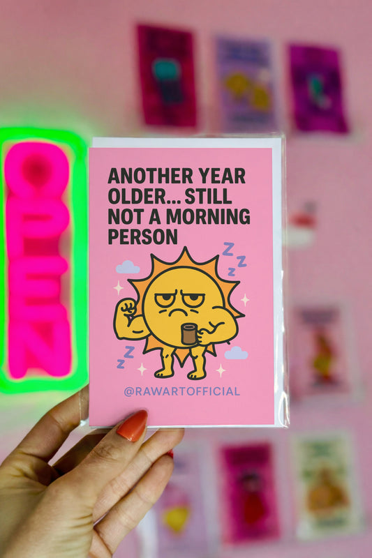 Grumpy muscular sun holding coffee, surrounded by clouds and sparkles on a pink birthday card.
