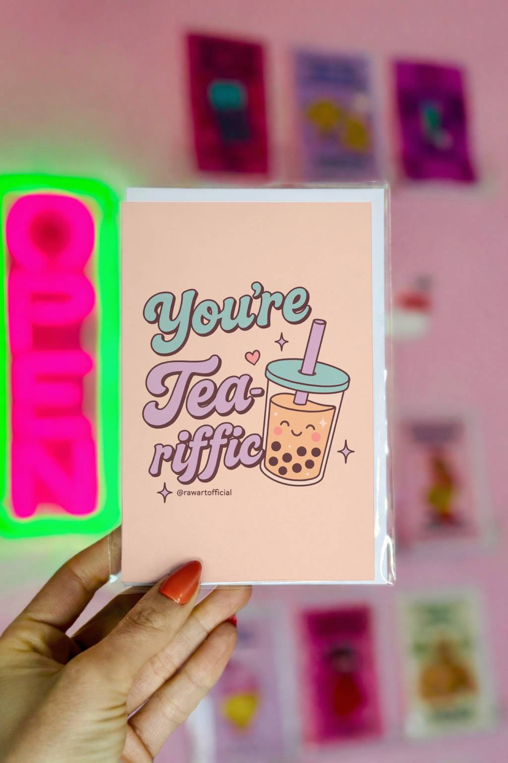 Cute pastel boba cup with smiling face and text “You’re Tea-riffic” in teal and lavender lettering, designed by @rawartofficial.