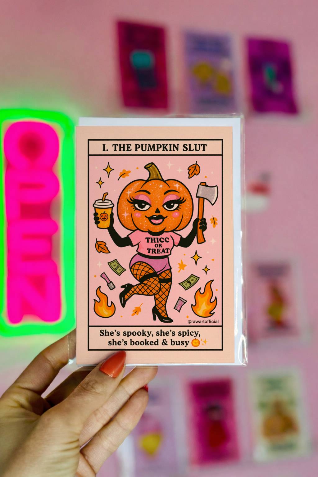 Pink Halloween card with a glam pumpkin-headed character in fishnets holding an axe and latte, text reads "he Pumpkin Slut"