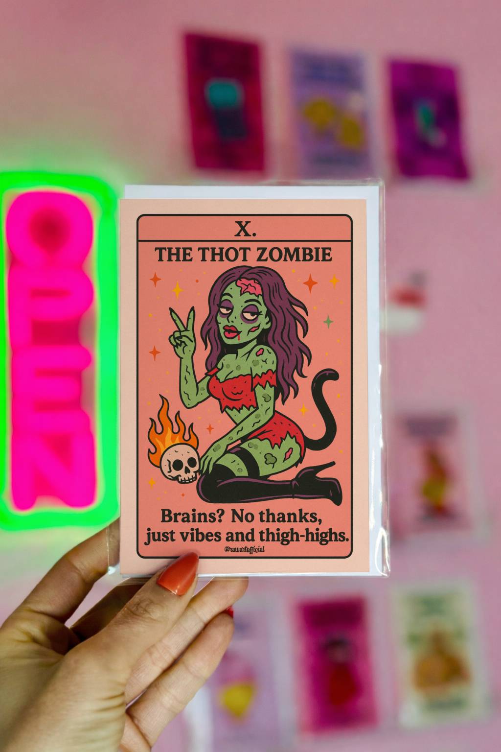 Illustrated green zombie pin-up with long hair and thigh-high boots, posing tarot card style with skull and flames, text “The Thot Zombie.”
