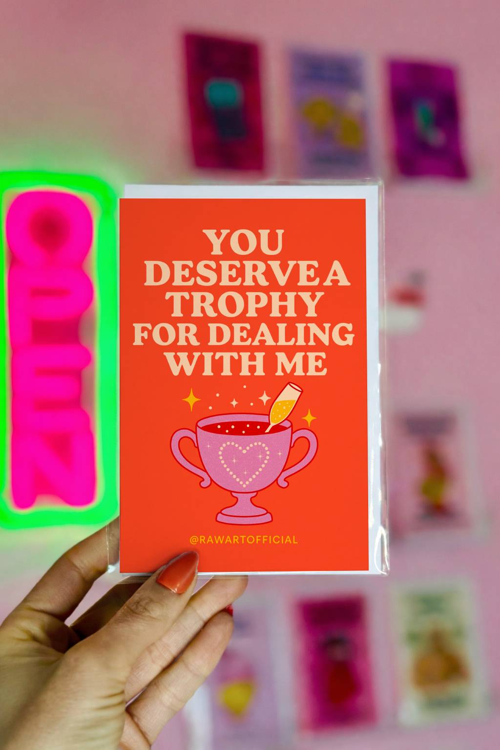 Greeting card featuring a pink trophy filled with champagne and the text “You Deserve a Trophy for Dealing With Me.”