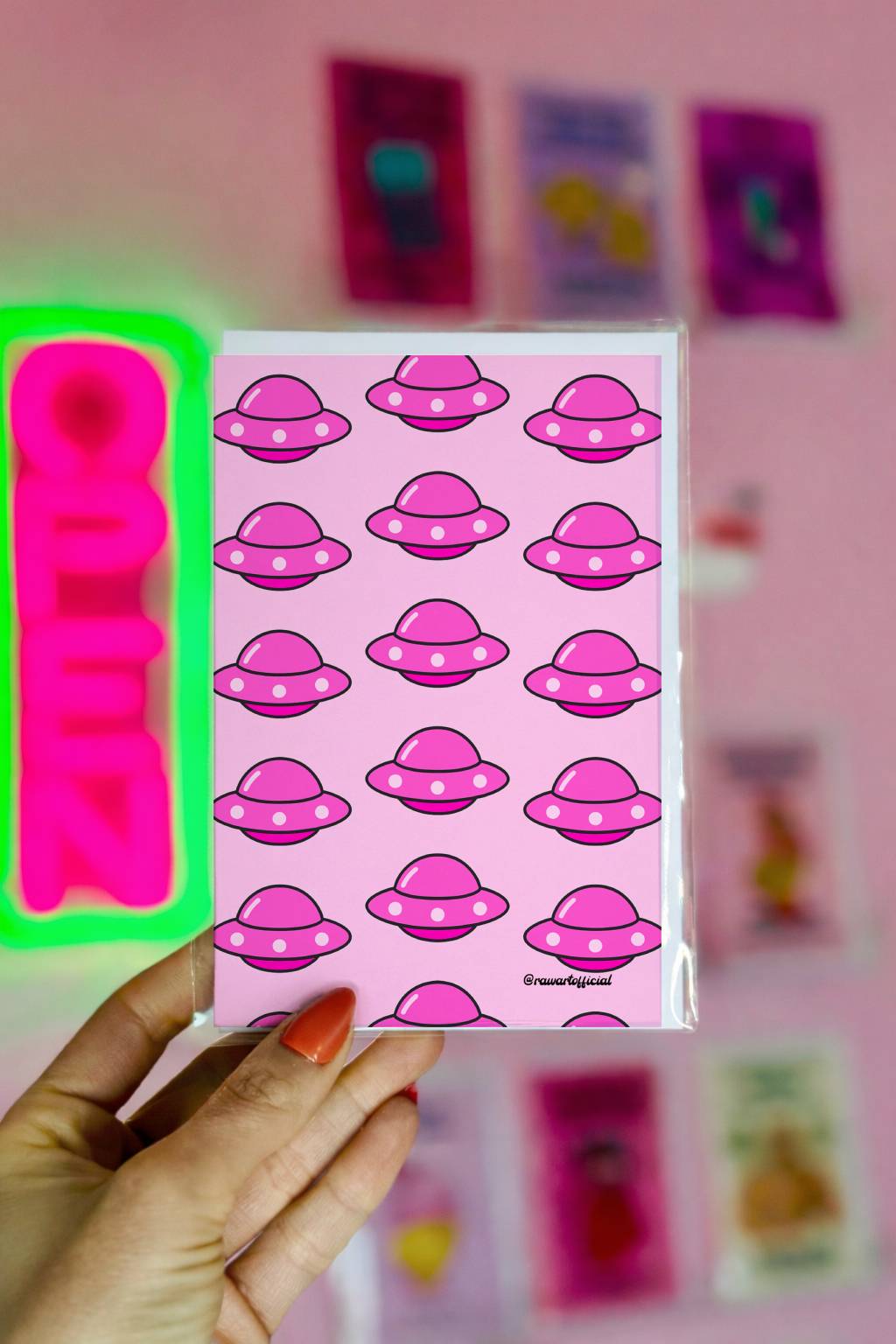 Greeting card featuring a repeating pattern of pink UFO illustrations on a pink background.
