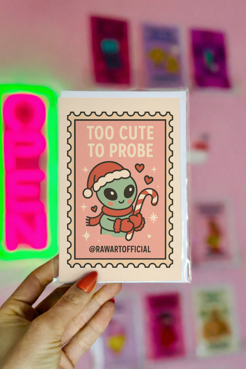 Cute pink alien Christmas card holding candy cane in retro stamp style.